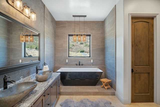 bathroom featuring tile walls, vanity, tile patterned flooring, and a bathtub