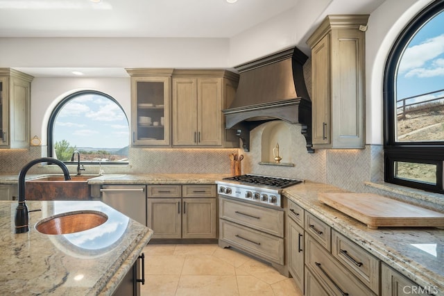 kitchen featuring custom range hood, backsplash, stainless steel appliances, and light stone counters