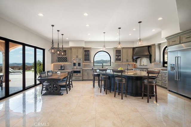 kitchen featuring a spacious island, appliances with stainless steel finishes, hanging light fixtures, and a wealth of natural light