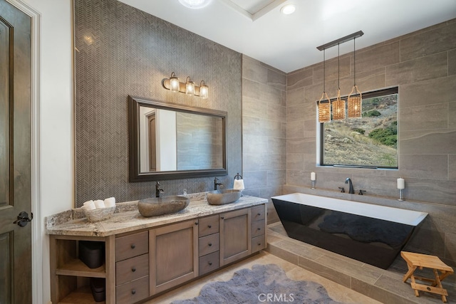 bathroom featuring vanity, a bathing tub, and tile walls