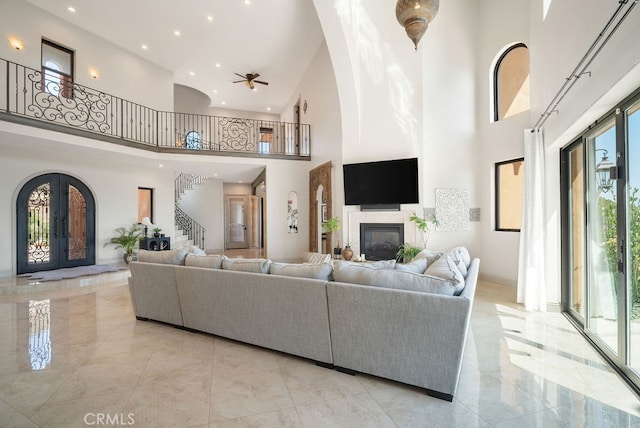 living room with a high ceiling and ceiling fan