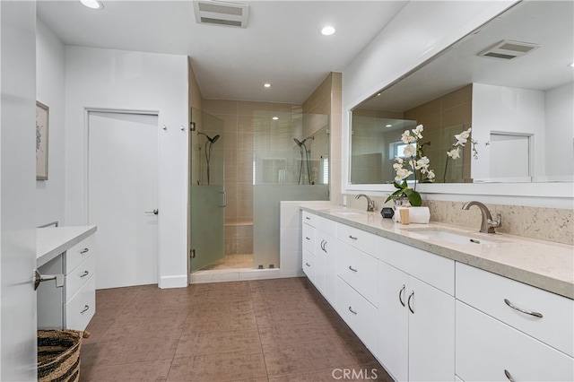 bathroom featuring tile patterned floors, a shower with door, and vanity