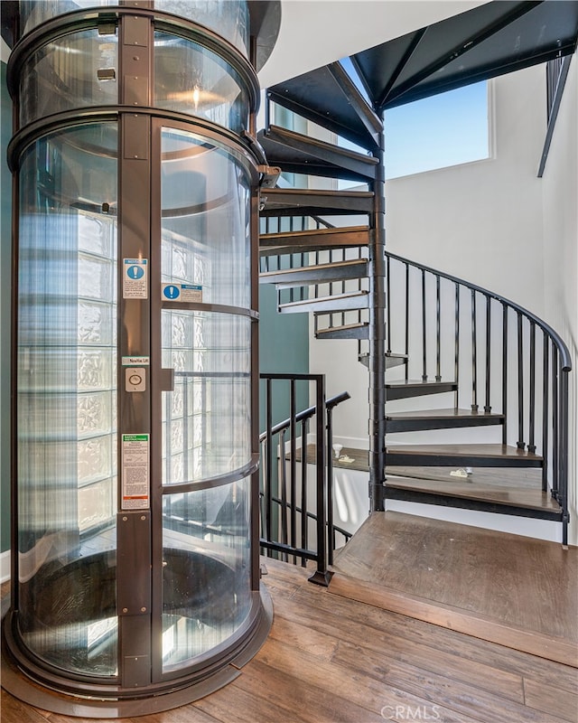 stairway with wood-type flooring, a wealth of natural light, and french doors