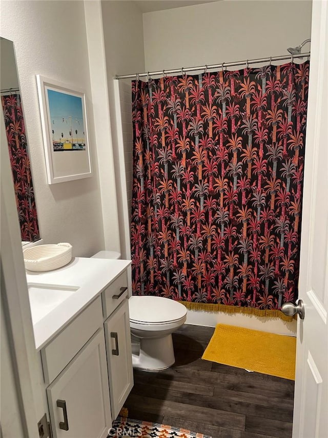 bathroom with hardwood / wood-style floors, vanity, toilet, and a shower with curtain