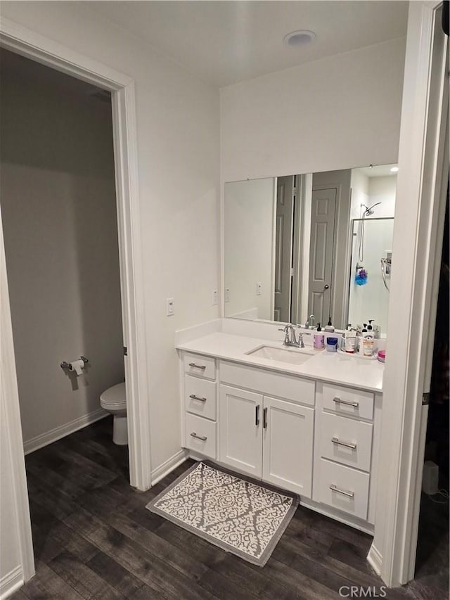 bathroom featuring walk in shower, toilet, vanity, and hardwood / wood-style flooring