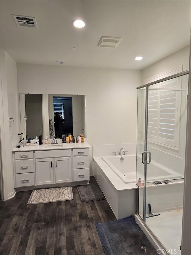 bathroom with hardwood / wood-style floors, vanity, and shower with separate bathtub