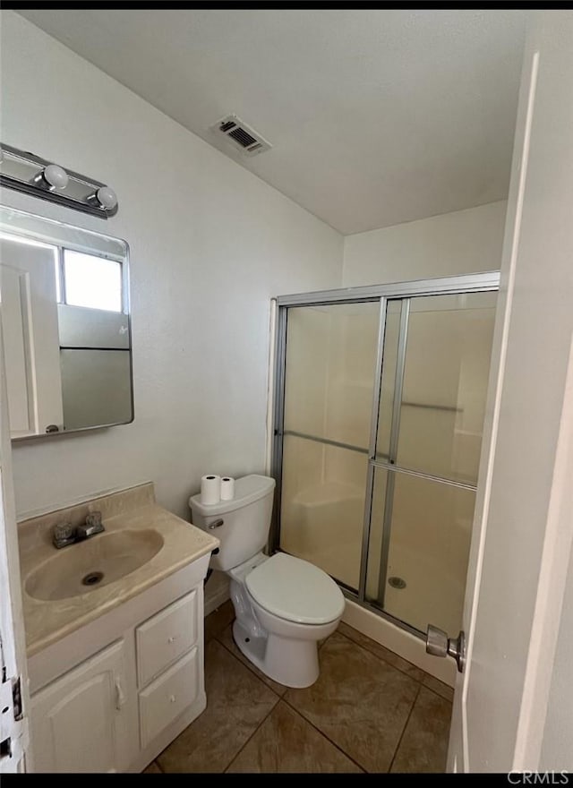 bathroom featuring tile patterned floors, vanity, toilet, and walk in shower