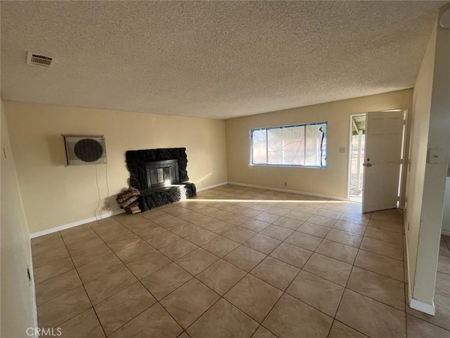 unfurnished living room with light tile patterned flooring, a wood stove, and a textured ceiling