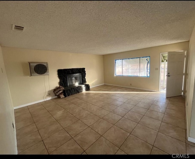 unfurnished living room with a fireplace, light tile patterned floors, and a textured ceiling