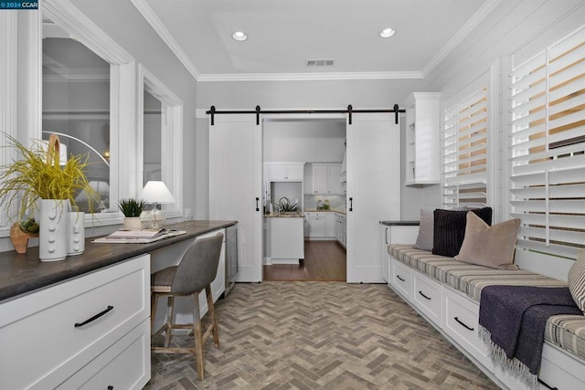 office area featuring a barn door and ornamental molding