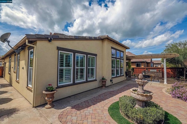 view of side of property featuring a pergola and a patio