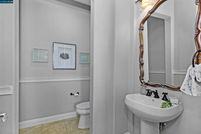 bathroom with tile patterned flooring, toilet, and sink