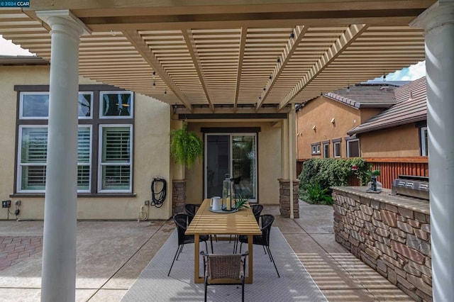 view of patio featuring exterior kitchen and a pergola