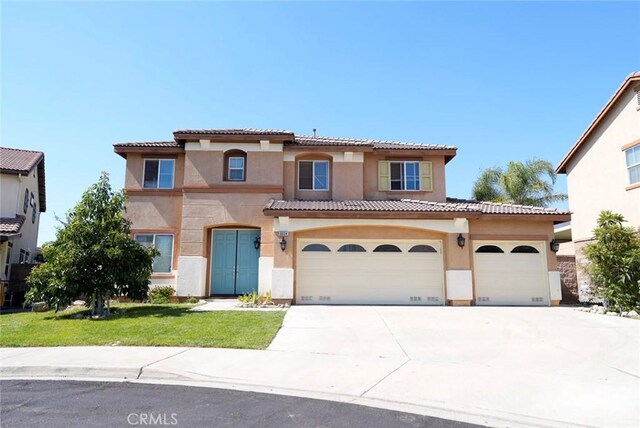 mediterranean / spanish-style home featuring a front lawn and a garage