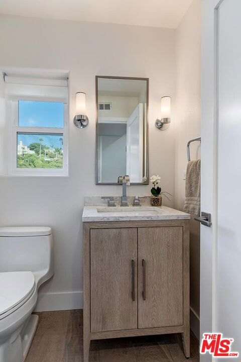 bathroom featuring vanity, toilet, and hardwood / wood-style flooring