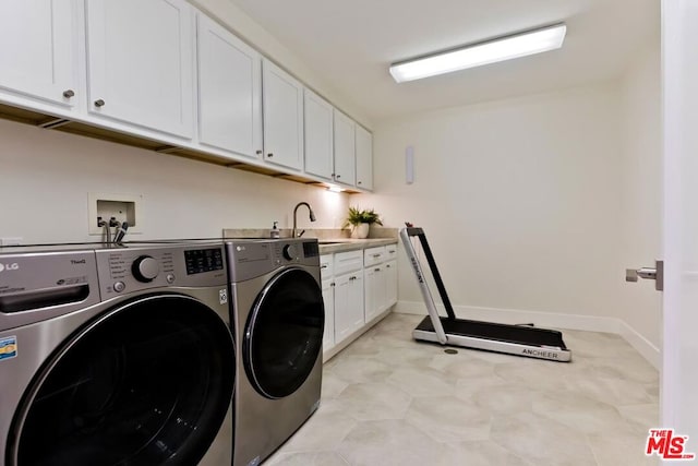 laundry area featuring cabinets, sink, and washing machine and dryer