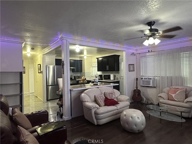 living room with ceiling fan, a textured ceiling, ornamental molding, and hardwood / wood-style flooring