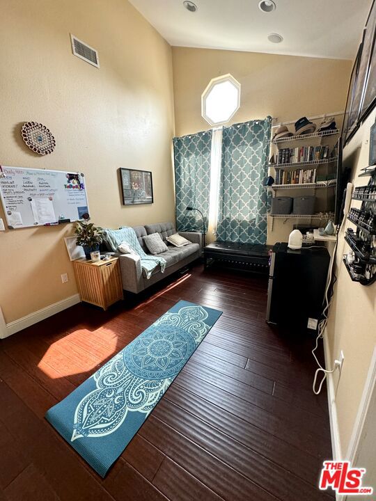 living room with vaulted ceiling and dark wood-type flooring