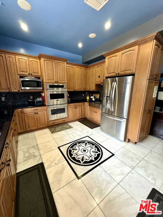 kitchen with stainless steel appliances and backsplash