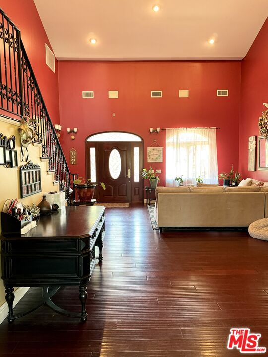 interior space with dark hardwood / wood-style flooring and a high ceiling