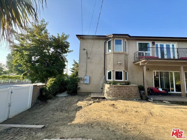 back of house featuring a balcony and a patio