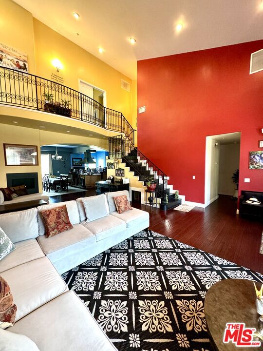 living room with a high ceiling and hardwood / wood-style flooring