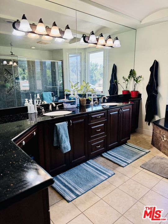 bathroom with vanity, tile patterned floors, and a shower with shower door