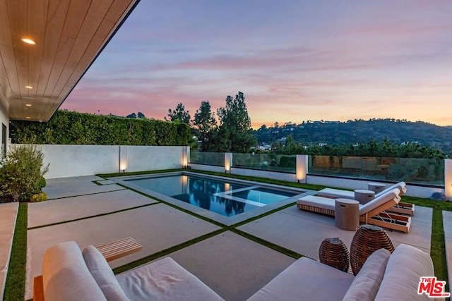 pool at dusk with a patio