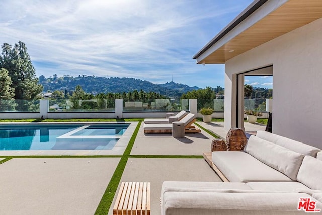 view of swimming pool featuring a mountain view, an outdoor living space, and a patio area