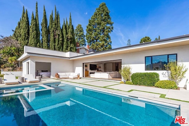 rear view of house with outdoor lounge area and a patio