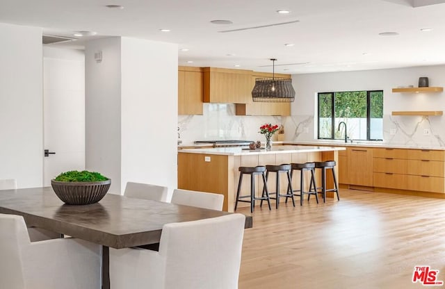 dining area featuring light wood-type flooring and sink