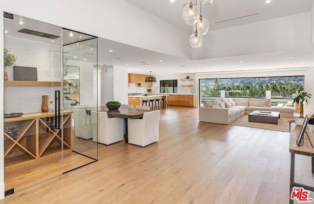 interior space with sink, light hardwood / wood-style floors, and a high ceiling