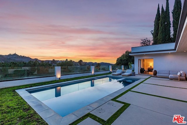 pool at dusk with a patio