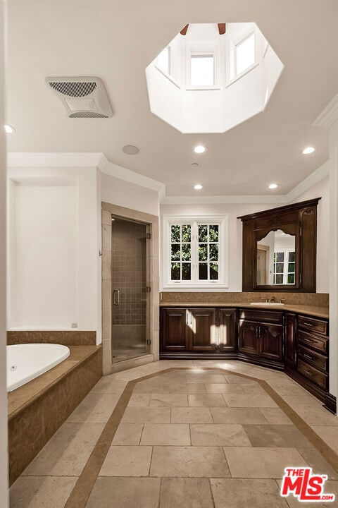 bathroom featuring ornamental molding, a skylight, independent shower and bath, and vanity