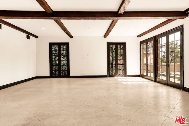 unfurnished room with beamed ceiling, plenty of natural light, and french doors