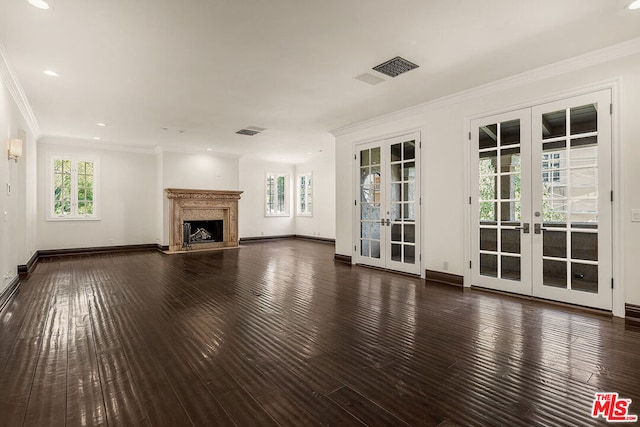 unfurnished living room with ornamental molding, dark hardwood / wood-style floors, a high end fireplace, and french doors