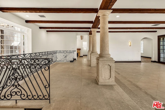 interior space with beamed ceiling and decorative columns