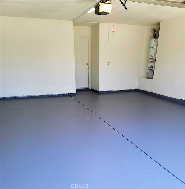 garage featuring strapped water heater and a garage door opener