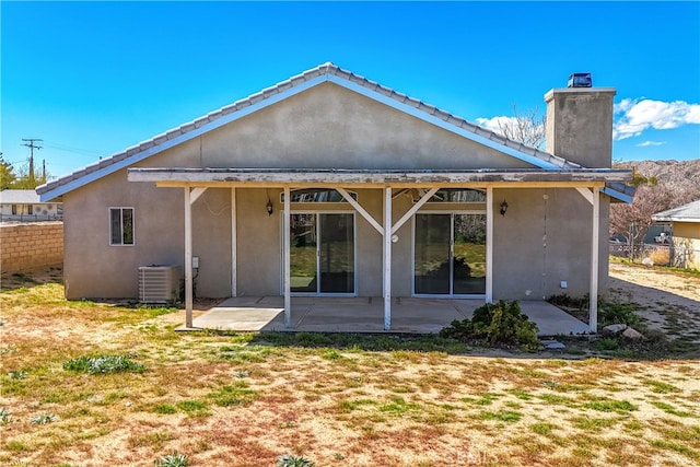 rear view of house with a lawn, a patio, and central AC