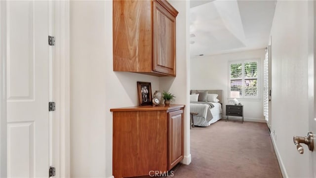 hallway featuring light colored carpet