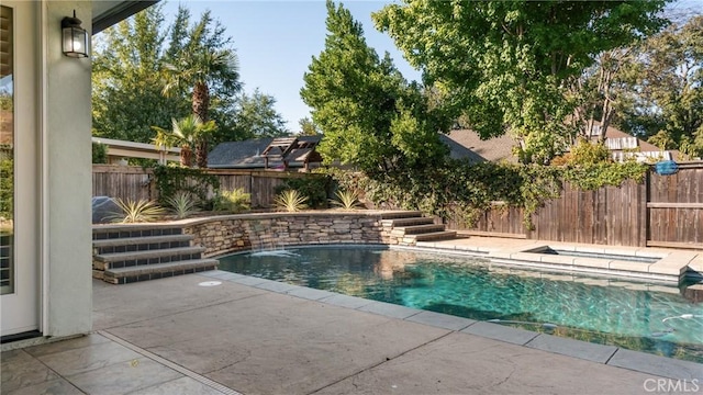 view of swimming pool with pool water feature and a patio area