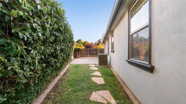 view of yard with cooling unit and a patio