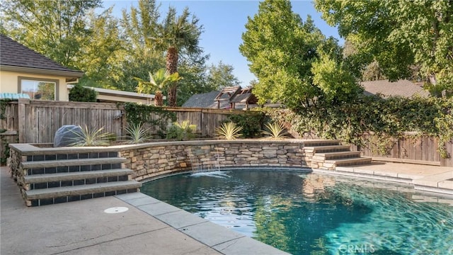 view of swimming pool with pool water feature and a patio area