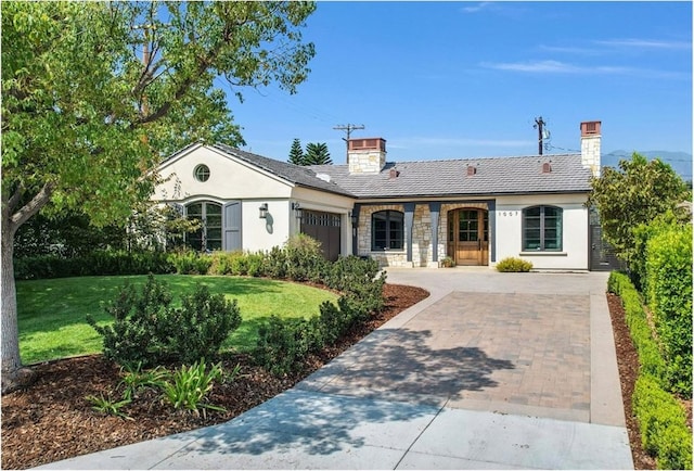 single story home featuring a garage and a front lawn