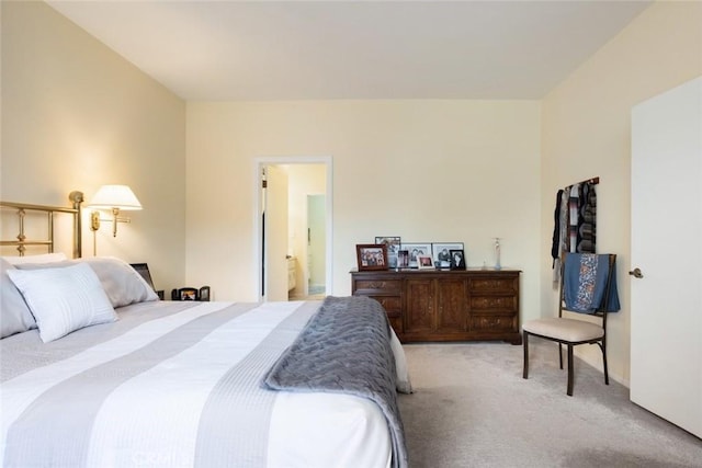 bedroom featuring light carpet and ensuite bathroom