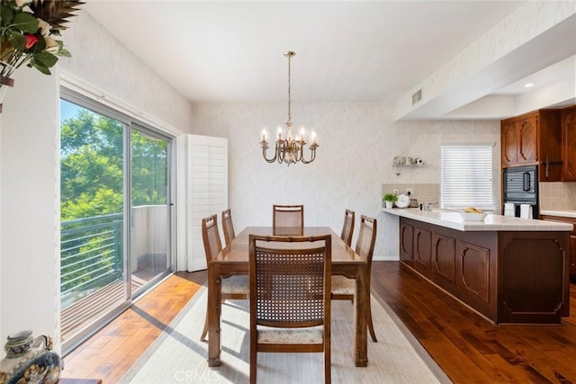 dining room featuring dark hardwood / wood-style floors and an inviting chandelier