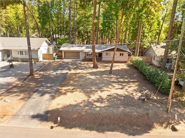 ranch-style house with driveway, a garage, and fence