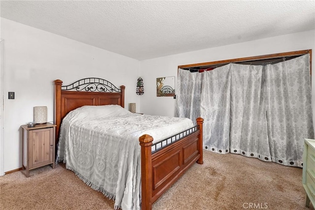 bedroom featuring baseboards, light carpet, and a textured ceiling