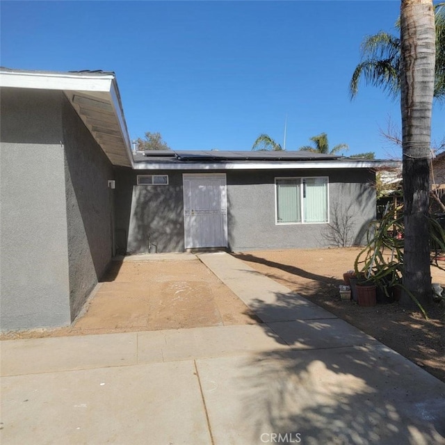 view of exterior entry with a patio area