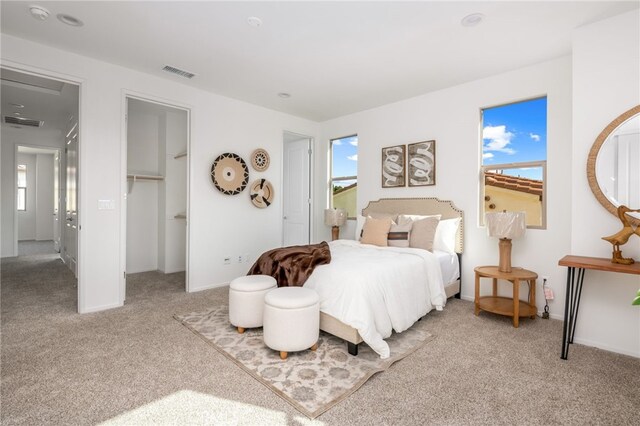 carpeted bedroom with a walk in closet